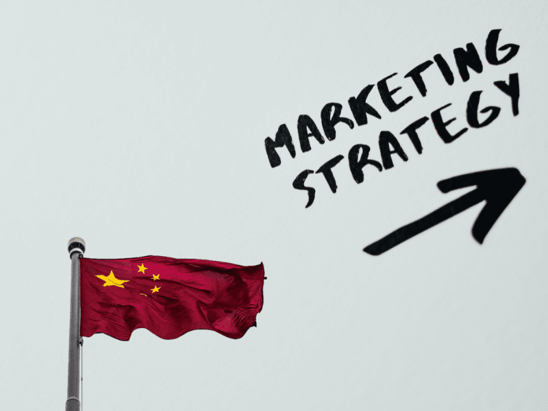 Chinese flag with the text marketing strategy and an arrow below it.